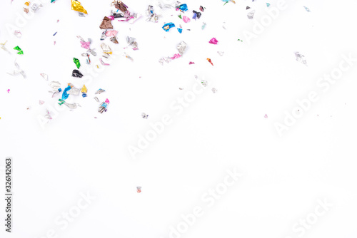 Multicolored confetti on white background. Flat lay, top view.