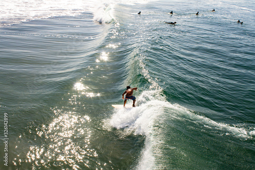 surfers surfing waves on the ocean by a beach