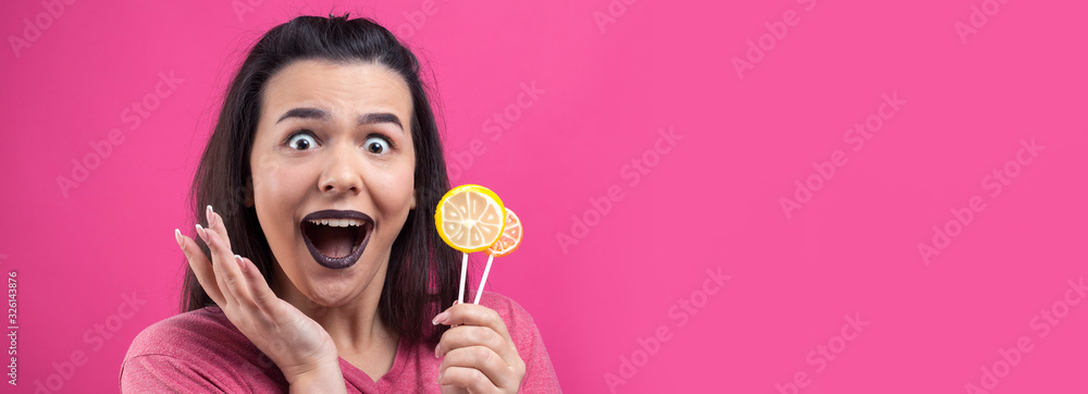 Portrait of lovely sweet beautiful cheerful woman with straight brown hair holding a lollipop near the eyes. Portrait of lovely sweet beautiful cheerful woman with straight brown hair holding a lollipop near the eyes.