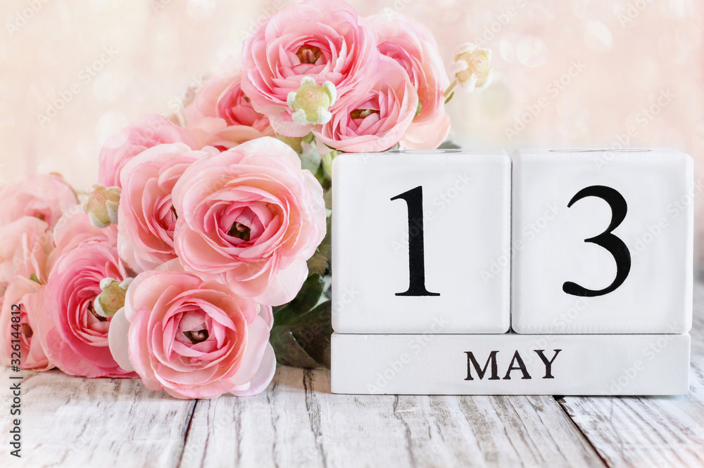 Fototapeta premium White wood calendar blocks with the date May 13th for National Receptionists Day. Selective focus with blurred background.