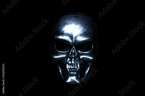 Silver mask skull with sharp teeth on a black background