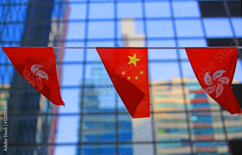 Photography chinese and hong kong flags blow in the wind with glass building background