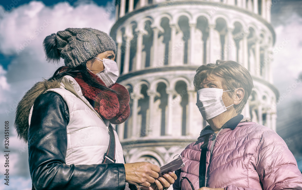 Coronavirus alarm in Italy, Europe. Woman  with her mother wearing respirator mask visiting Pisa Leaning Tower. New type Covid-19 virus has been spreading in many cities in Italy