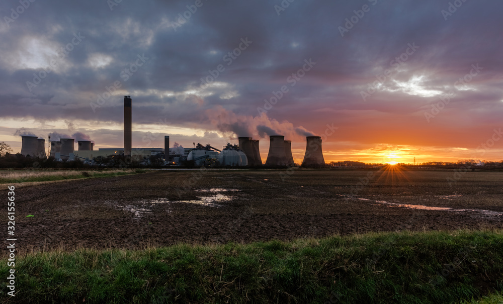 Drax, North Yorkshire, early morning in February, with the sun rising behind the cooling towers of a local Power Station.  Horizontal. Space for copy.