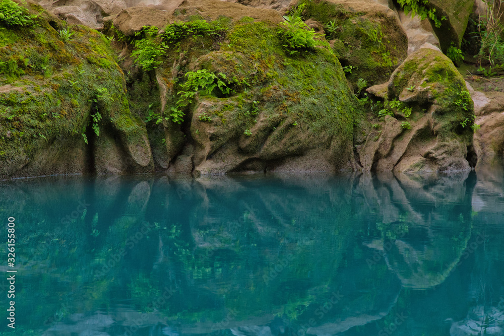 Fototapeta premium Amazing crystalline blue water of Tamul waterfall, Close up view of spectacular Tamul River,at Huasteca Potosina in San Luis Potosi, Mexico