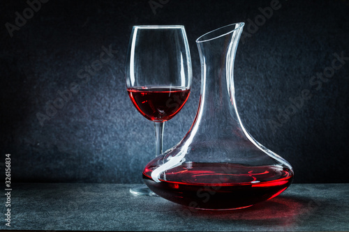 Photos wineglass and decanator with red  wine on dark background
