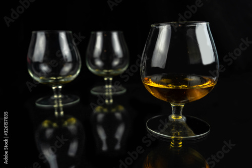 Three whiskey / cognac glasses on a black dark background