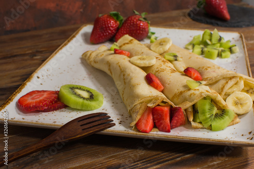 Healthy crepes with fruits, banana, kiwi and strawberry. Healthy french breakfast