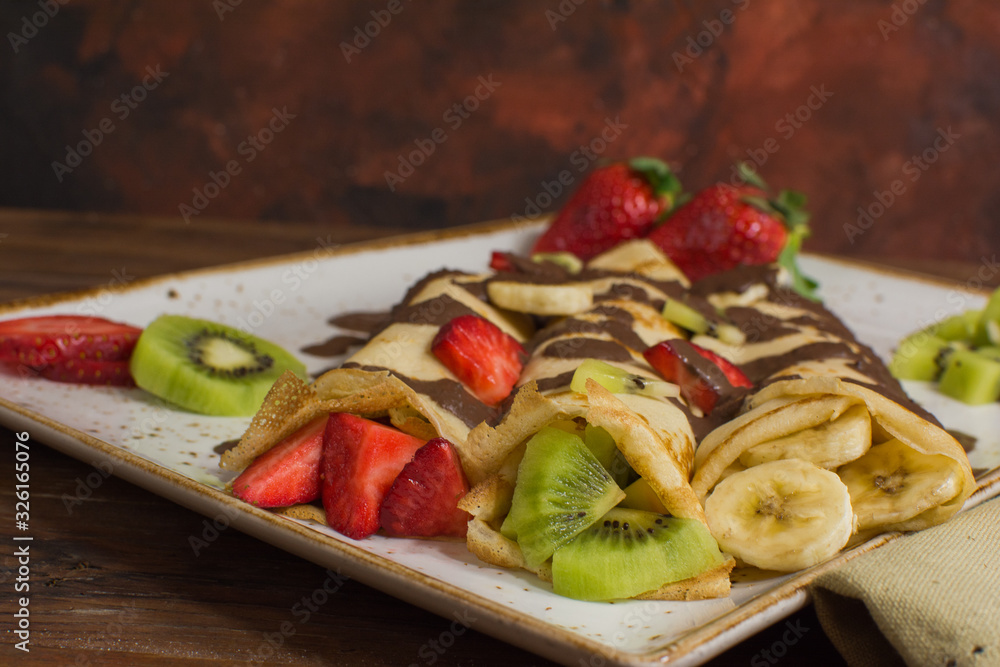 Healthy crepes with fruits, banana, kiwi and strawberry. Healthy french breakfast