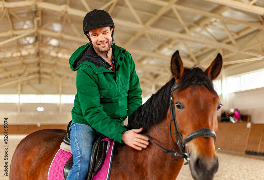 man jockey sitting on horse, horseback training on manege, lesson for jockey in equestrian school or club, pet animal