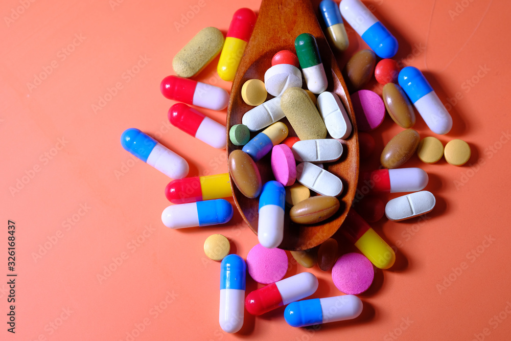 Close up of colored pills and capsule on spoon Close up of colored pills and capsule on spoon