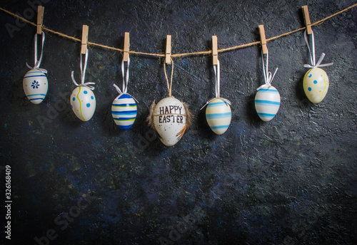 Colorful easter egg on blue pastel color wood background with space.