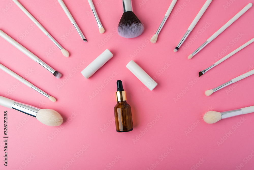 white makeup brushes and tubes on a pink background white makeup brushes and tubes on a pink background