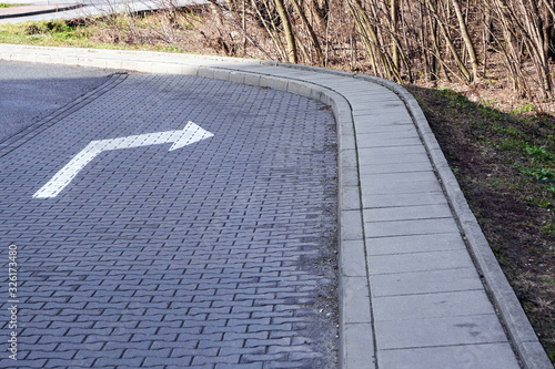 A road turn sign or a drawn marker to nowhere, a turn from the curb. Mismatch of signs and reality, safety at the wheel.
