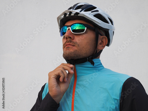 Portrait of a male Cyclist zipping up a windbreaker before riding a bike.  photo