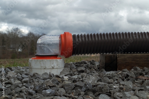 RV sewer hose connected to dump station with 90 degree clear fitting