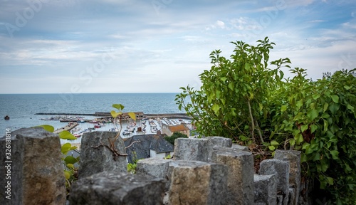 view of port behind stone wall with the sea in the background in england