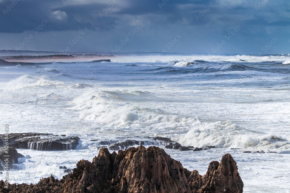 Dramatic waves rolling and breaking on rocky coastline