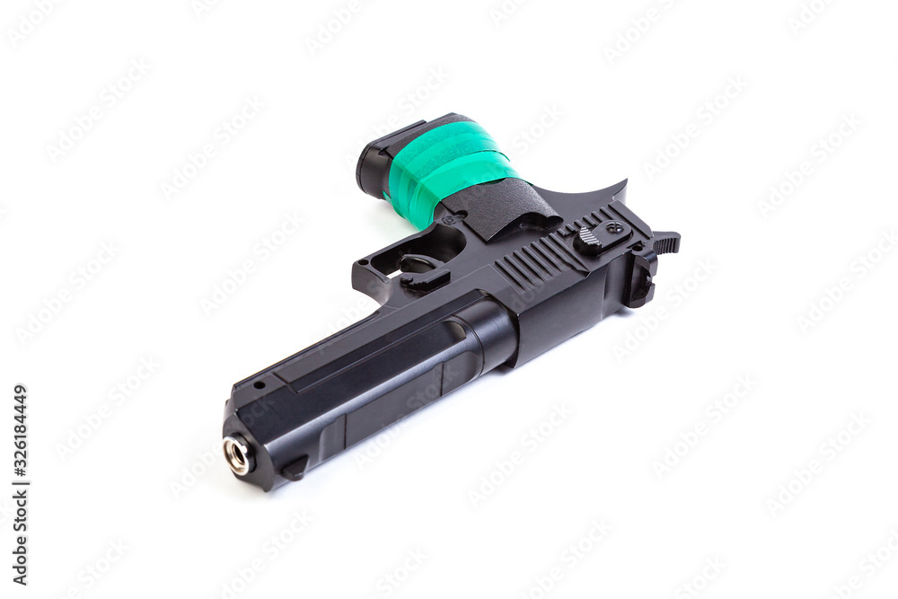 Black steel pistol with a handle wrapped in green electrical tape on a white isolated background Black steel pistol with a handle wrapped in green electrical tape on a white isolated background