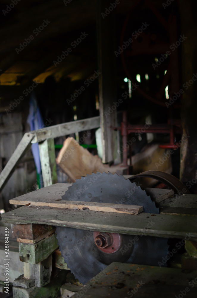 circular saw in traditional sawmill on wooden desk in the penunmbra.