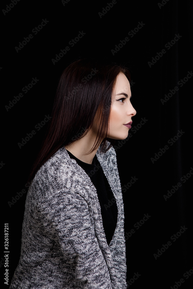 Portrait of cute woman which is looking to the side. Full face on a black background Portrait of cute woman which is looking to the side. Full face on a black background
