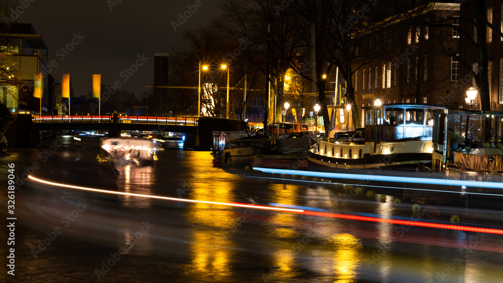 Amsterdam Canal at silent night with moving boats