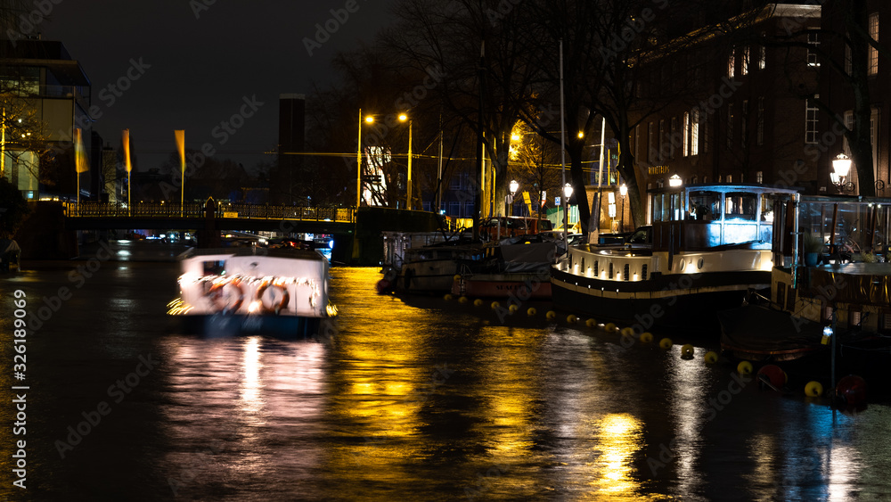 Amsterdam Canal at silent night with moving boat
