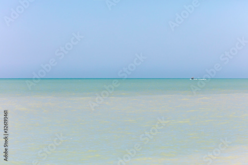 Calm ocean and in the background a small boat, Florida photo