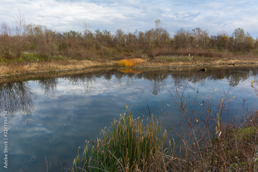 Small lake surrounded by vegetation in autumn colors. Shoot while searching for fishing grounds.