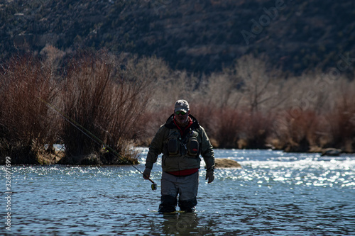 A man fly fishing on the San Jaun river in the winter.