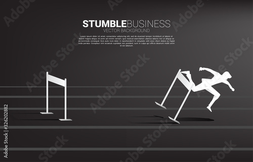 Silhouette of businessman stumbling during across hurdles obstacle. Concept for fail and accidental business