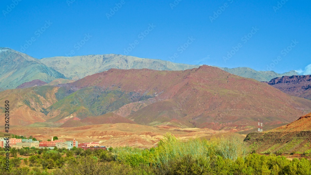 Landscape of High Atlas Mountains with houses at the foot of the colorful mountains in Morocco