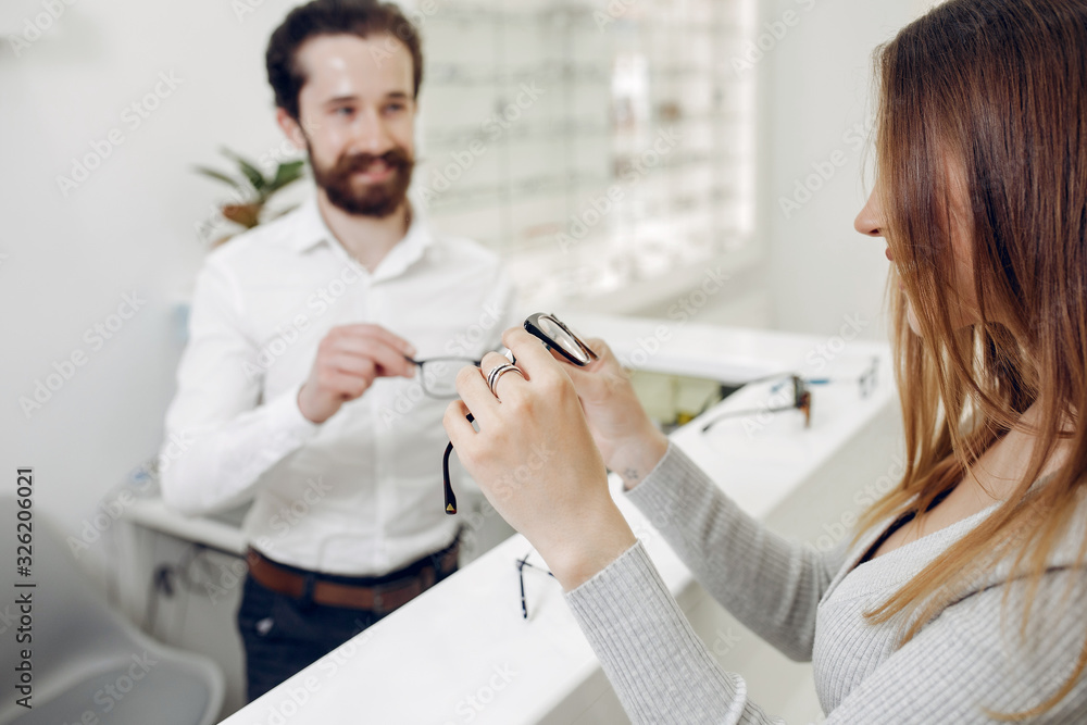 Mother with cute son. Family buy glasses. Assistant helping the clients Mother with cute son. Family buy glasses. Assistant helping the clients