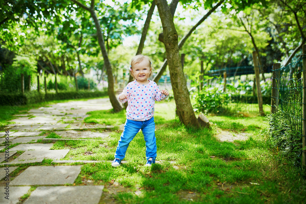 Adorable baby girl walking in green park on a summer day Adorable baby girl walking in green park on a summer day