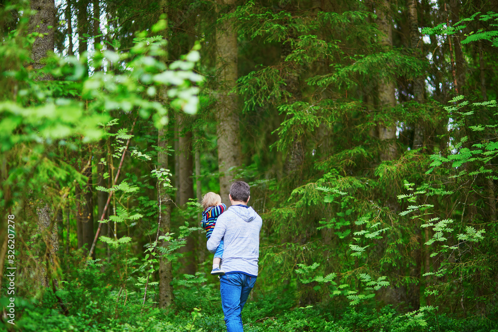 Father carrying his child during walk in forest Father carrying his child during walk in forest