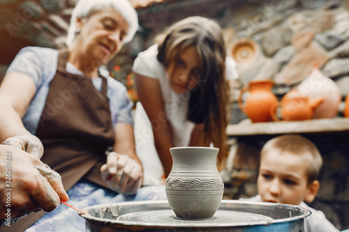 Family make a small jug. Hands of a potter at work.
