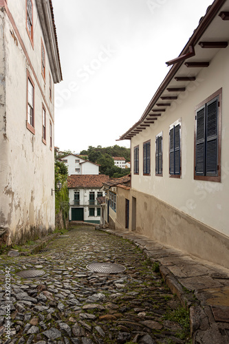 Wet cobblestone back street with typical historic colonial architecture