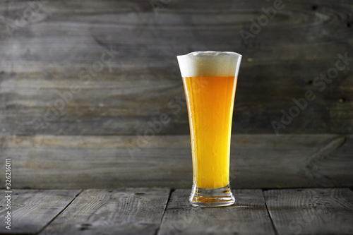 Glass beer on wood background with copyspace .