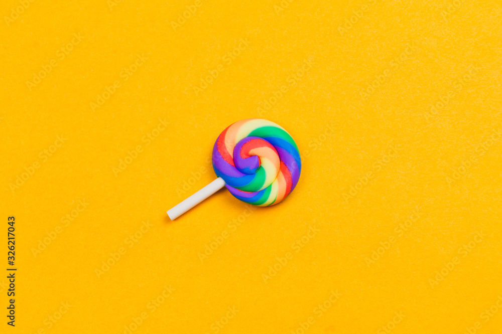 Lollipop close up. colorful candy on a yellow background. spiral caramel Lollipop close up. colorful candy on a yellow background. spiral caramel