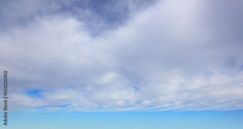 Light blue spring sky with large light clouds as background.