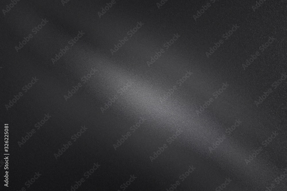 Light shining through on black dirt metal wall in dark room, abstract texture background