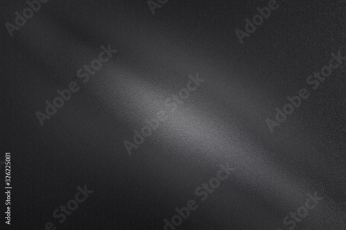 Light shining through on black dirt metal wall in dark room, abstract texture background