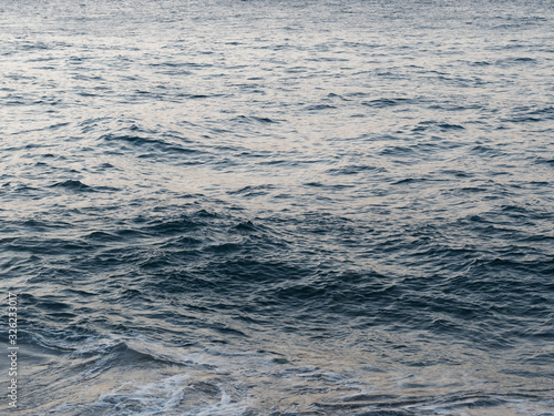 Sea or ocean ripple water at sunset.