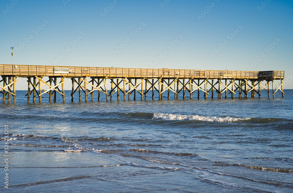 Anglerpier, Pier aus Holz die über das Meer ins Wasser ragt bei wolkenlosem Himmel