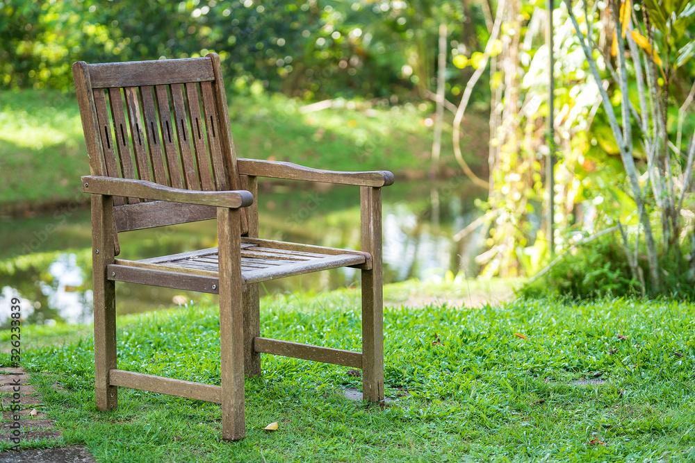Old wooden chair in a tropical garden near the lake in island Borneo, Malaysia Old wooden chair in a tropical garden near the lake in island Borneo, Malaysia