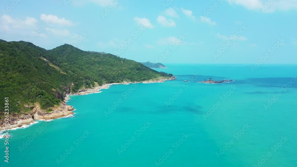 Calm turquoise sea washing beautiful rocky coastline of tropical island with cliffs down green trees forest in koh pha ngan, Thailand Calm turquoise sea washing beautiful rocky coastline of tropical island with cliffs down green trees forest in koh pha ngan, Thailand