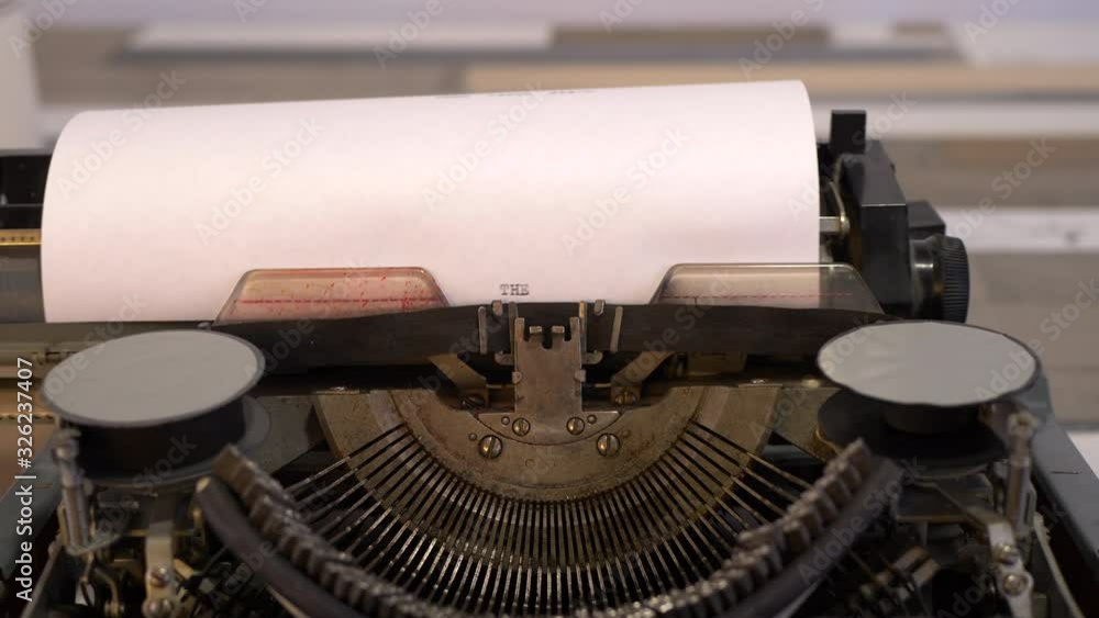 close-up typing a text THE END, old vintage typewriter with a sheet of paper close-up typing a text THE END, old vintage typewriter with a sheet of paper