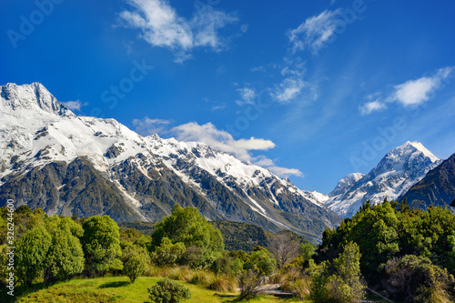 High mountain views on the top of the mountain are white snow in the summer with sky and clouds with green grass throughout the area in Mount Cook National Park in the island south of New Zealand. © Lowpower