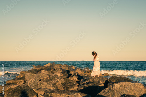 Girl Standing on Rocks Heading Out into the Water