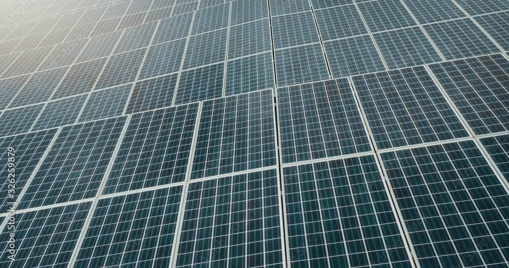 Aerial view of an endless array of solar panels generating energy from the sun on a solar farm, the renewable green energy future is here Aerial view of an endless array of solar panels generating energy from the sun on a solar farm, the renewable green energy future is here